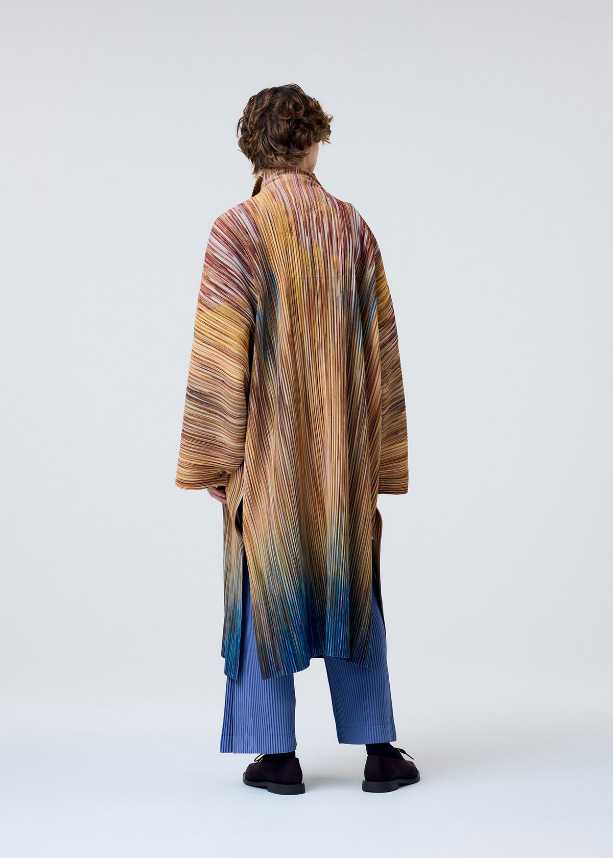A model wears the HOMME PLISSÉ ISSEY MIYAKE PAINT BRUSH CLOSE UP coat.