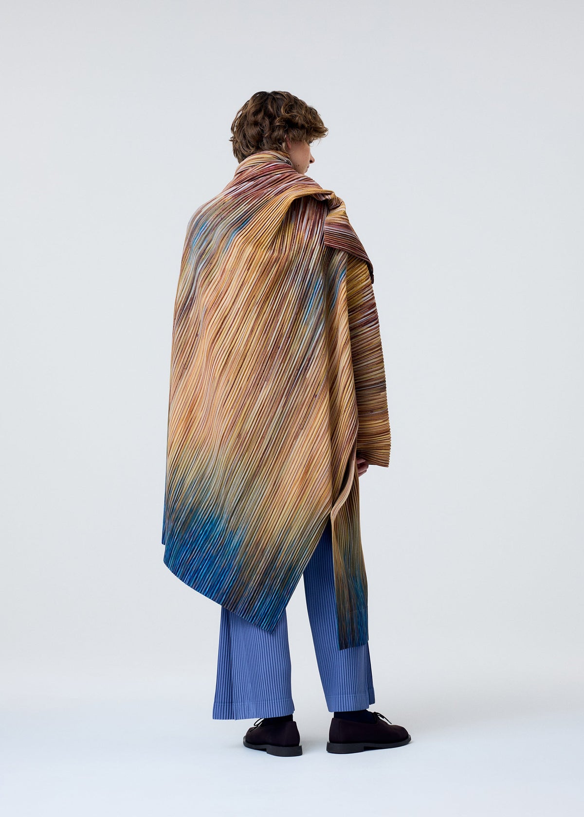 A model wears the HOMME PLISSÉ ISSEY MIYAKE PAINT BRUSH CLOSE UP coat.