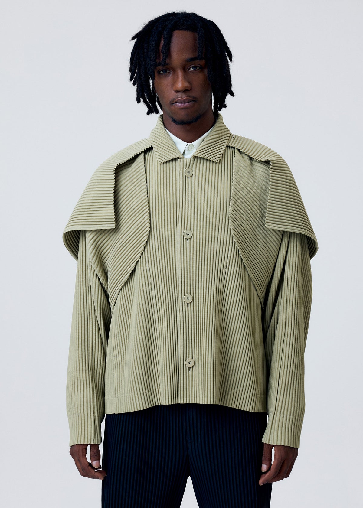 A model wears the HOMME PLISSÉ ISSEY MIYAKE COVER AND FOLD clothing.