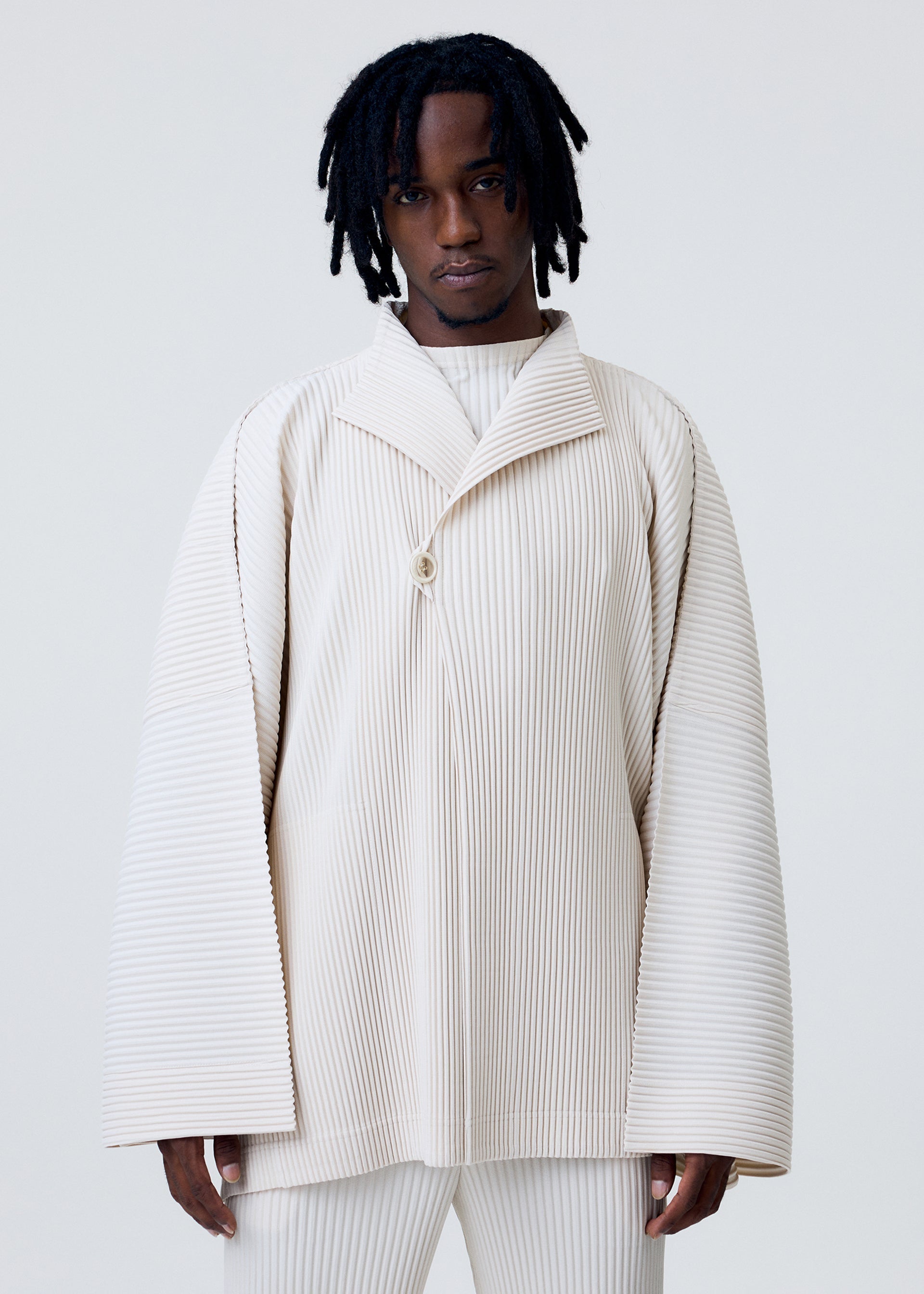 A model wears the HOMME PLISSÉ ISSEY MIYAKE WEAR OR WRAP jacket.