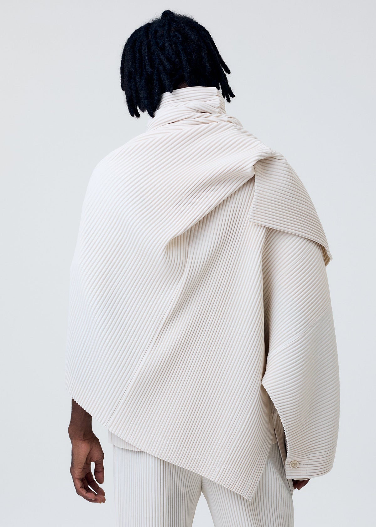 A model wears the HOMME PLISSÉ ISSEY MIYAKE WEAR OR WRAP jacket.