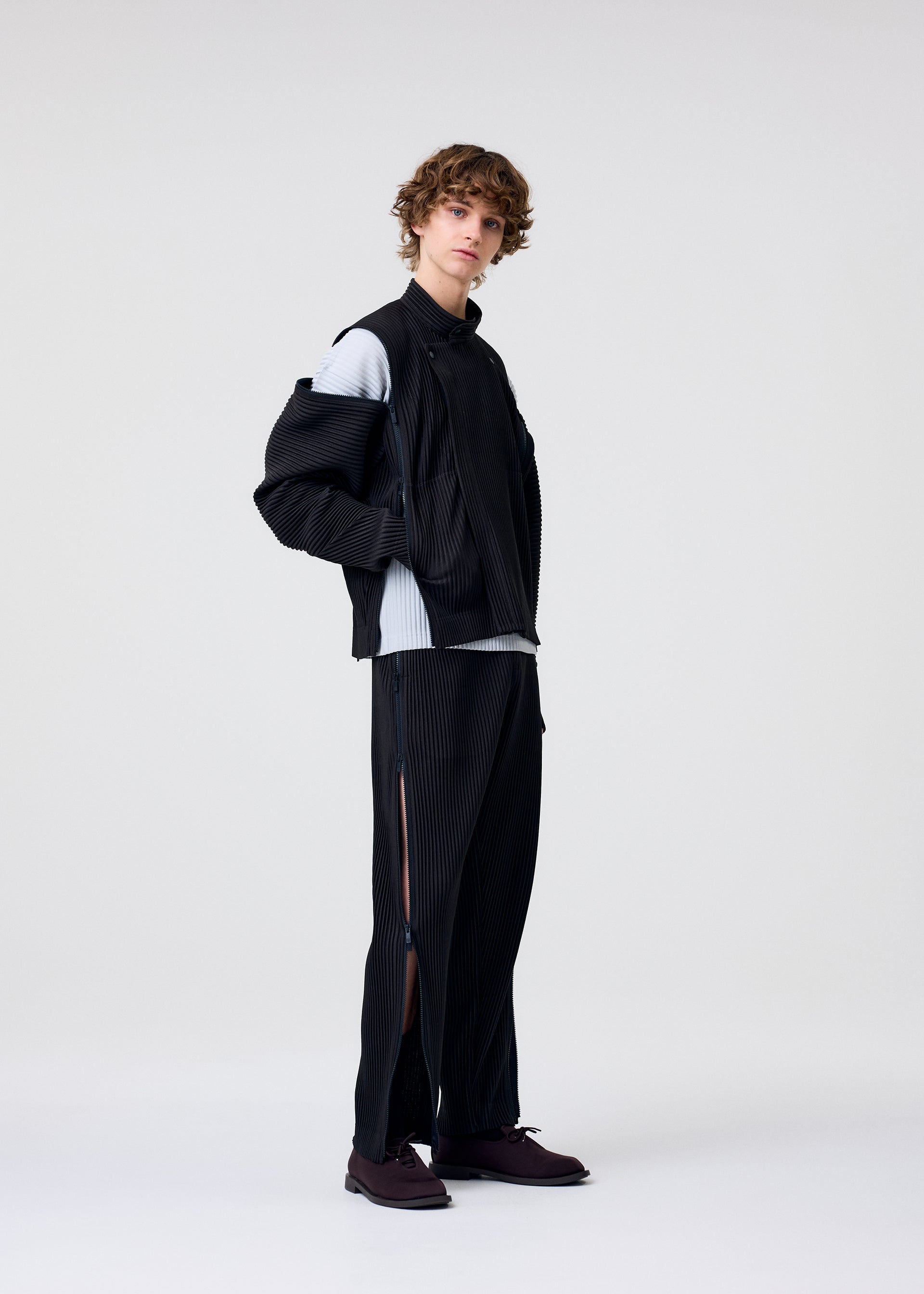 A model wears the HOMME PLISSÉ ISSEY MIYAKE MULTI-FASTENED multi-fastened-jacket-lucca-storico-blue.
