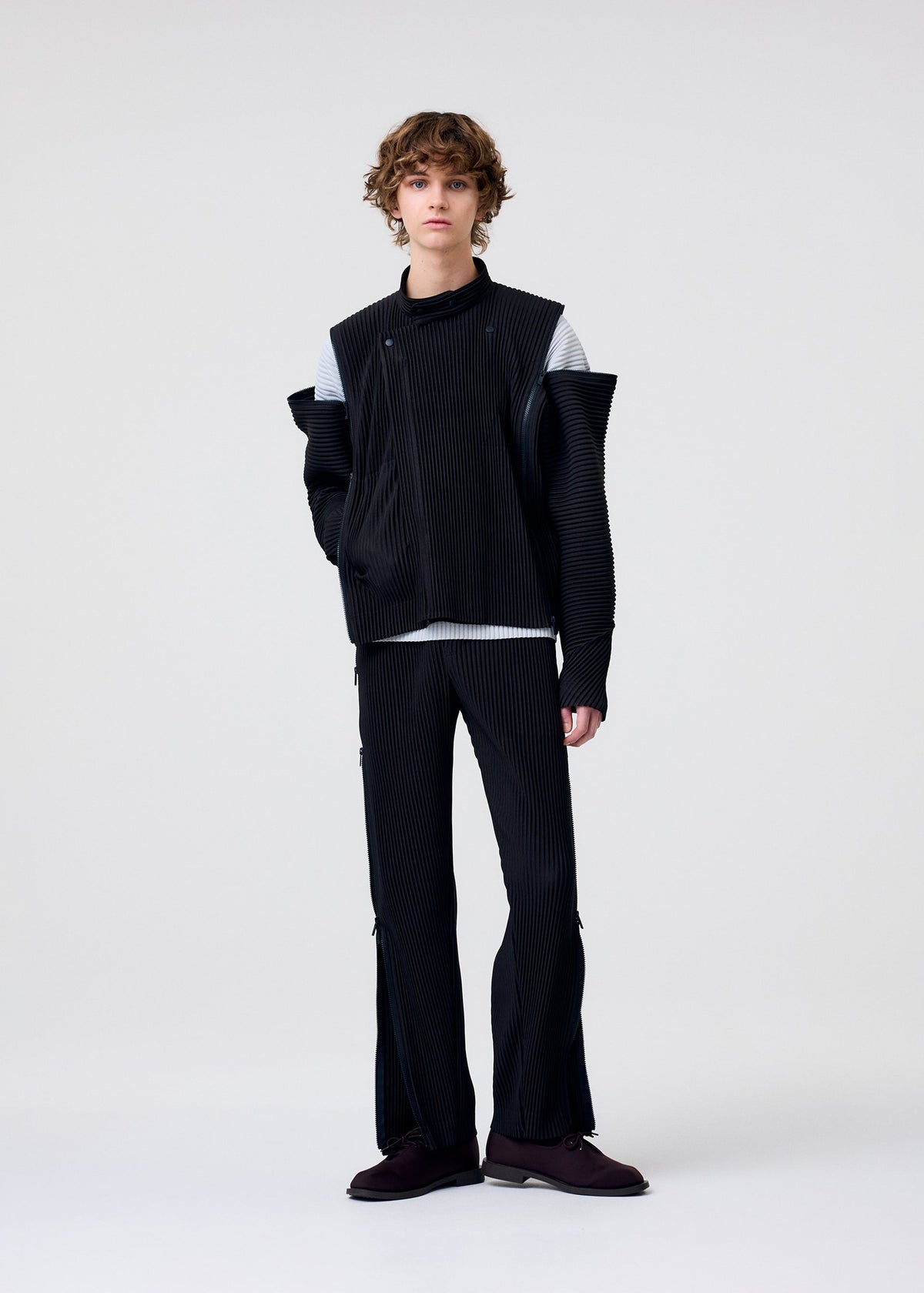 A model wears the HOMME PLISSÉ ISSEY MIYAKE MULTI-FASTENED multi-fastened-jacket-lucca-storico-blue.