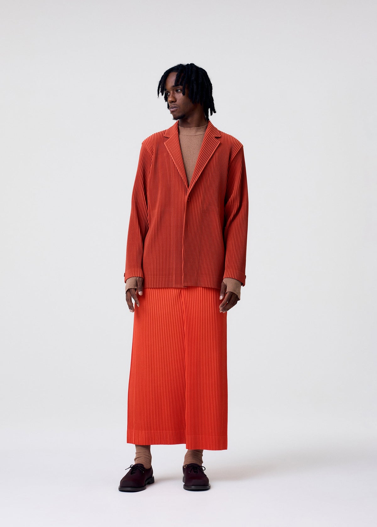 A model wears the HOMME PLISSÉ ISSEY MIYAKE TAILORED PLEATS 3 tailored-pleats-3-jacket-black.