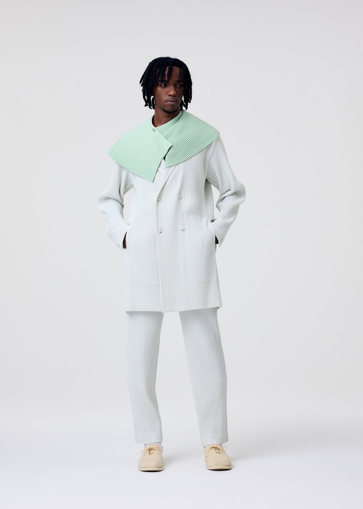 A model wears the HOMME PLISSÉ ISSEY MIYAKE TAILORED PLEATS 3 tailored-pleats-3-jacket-jambon-pink-1.
