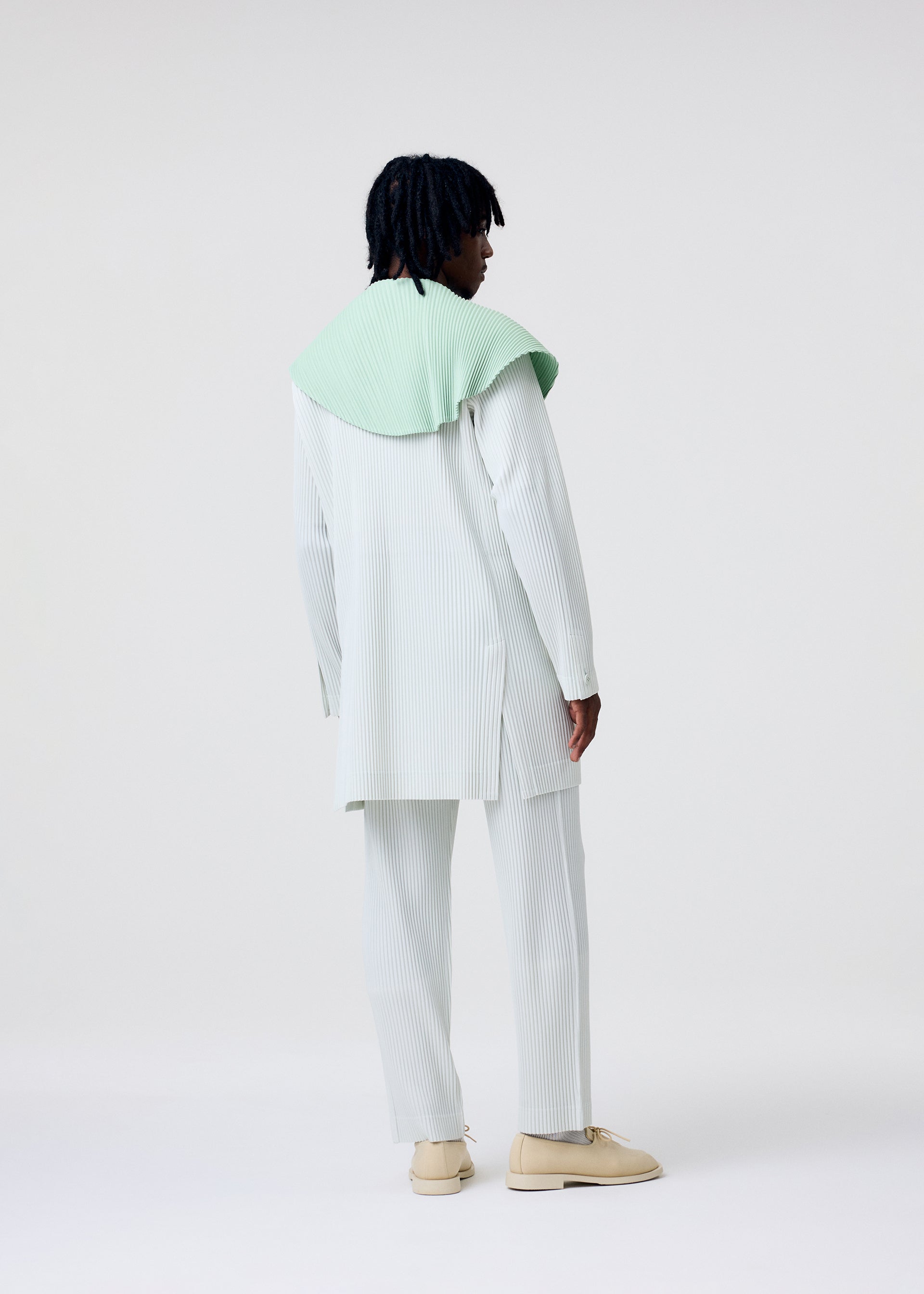 A model wears the HOMME PLISSÉ ISSEY MIYAKE TAILORED PLEATS 3 tailored-pleats-3-jacket-black-1.