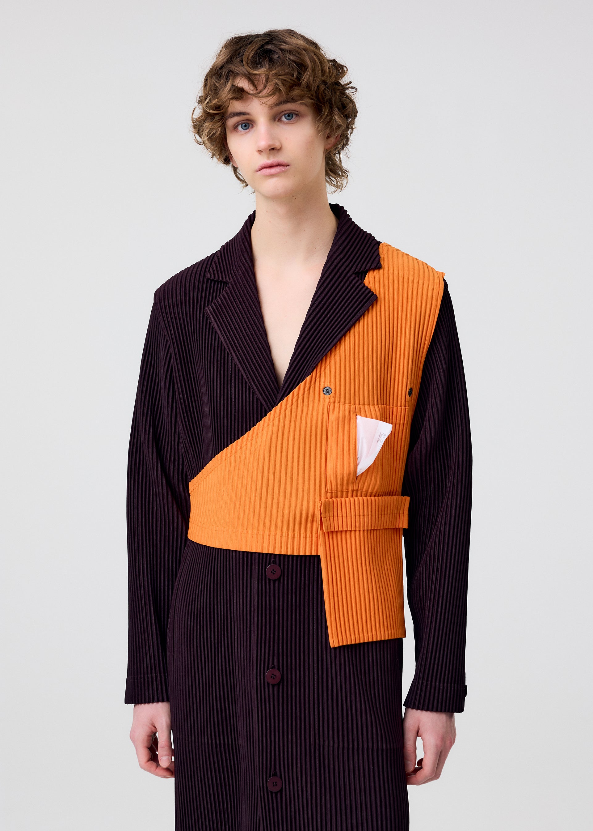 A model wears the HOMME PLISSÉ ISSEY MIYAKE PAINTER'S GEAR vest.