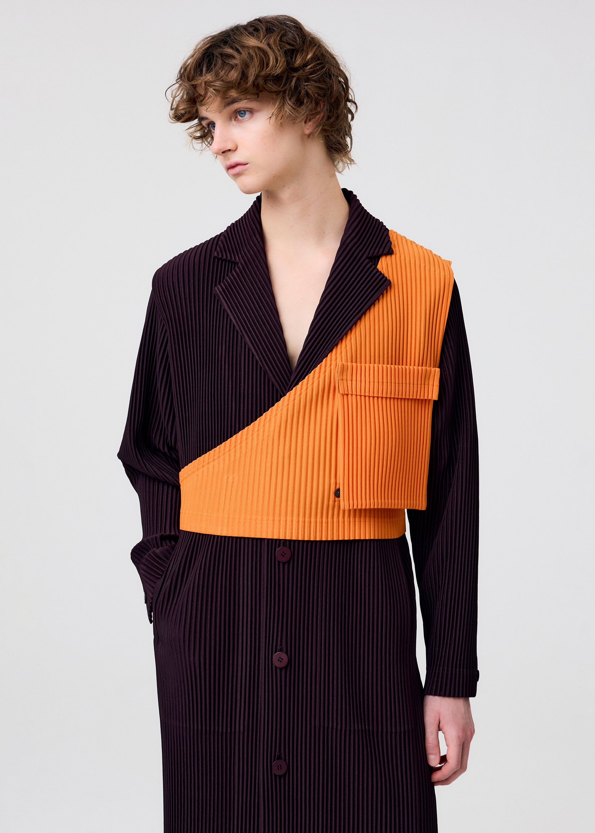 A model wears the HOMME PLISSÉ ISSEY MIYAKE PAINTER'S GEAR vest.