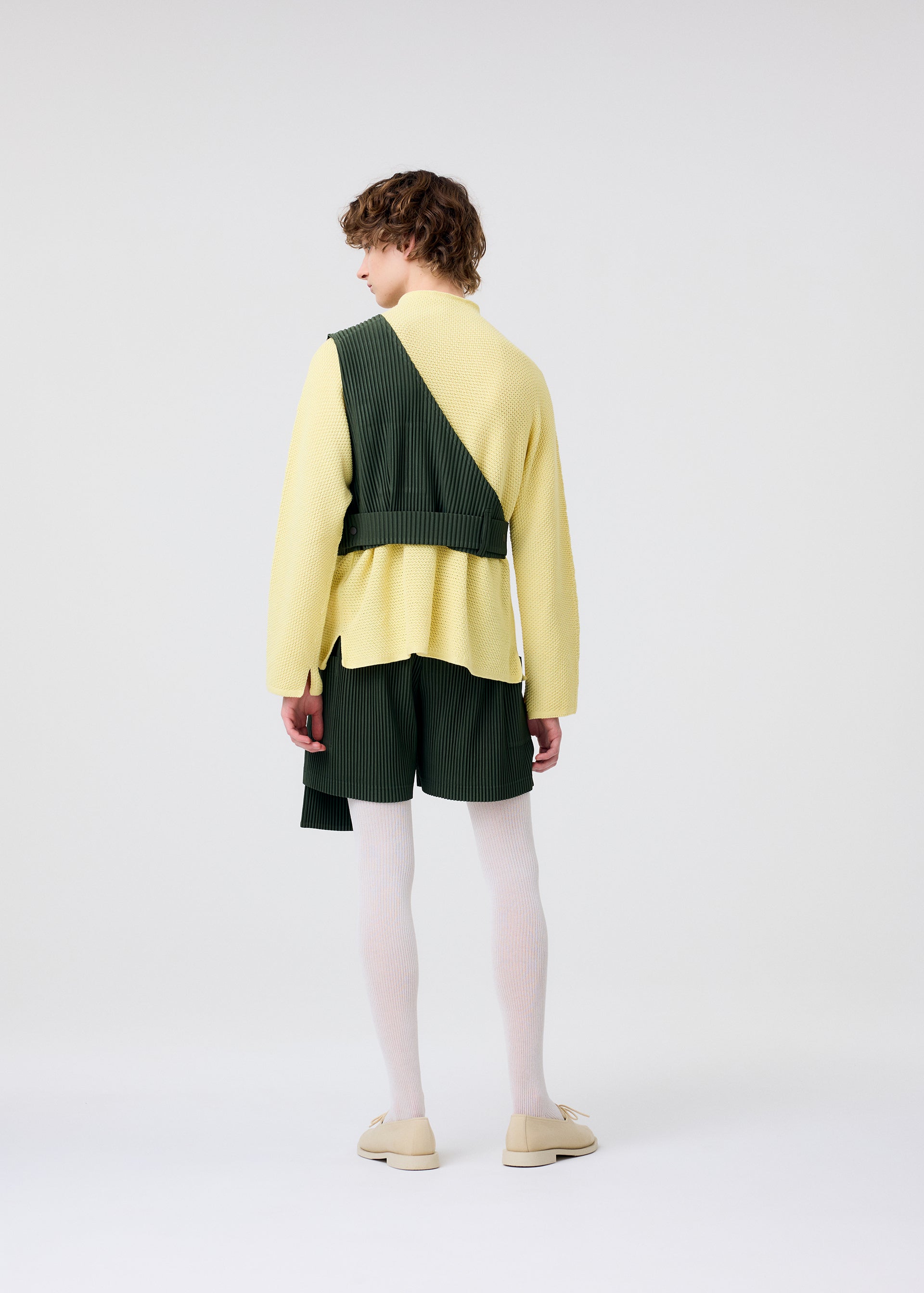 A model wears the HOMME PLISSÉ ISSEY MIYAKE PAINTER'S GEAR vest.