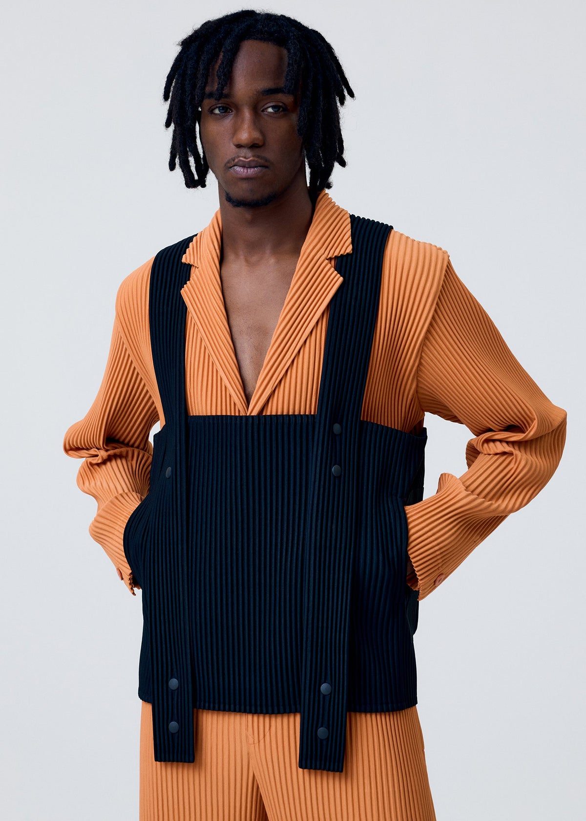 A model wears the HOMME PLISSÉ ISSEY MIYAKE PAINTER'S GEAR vest.