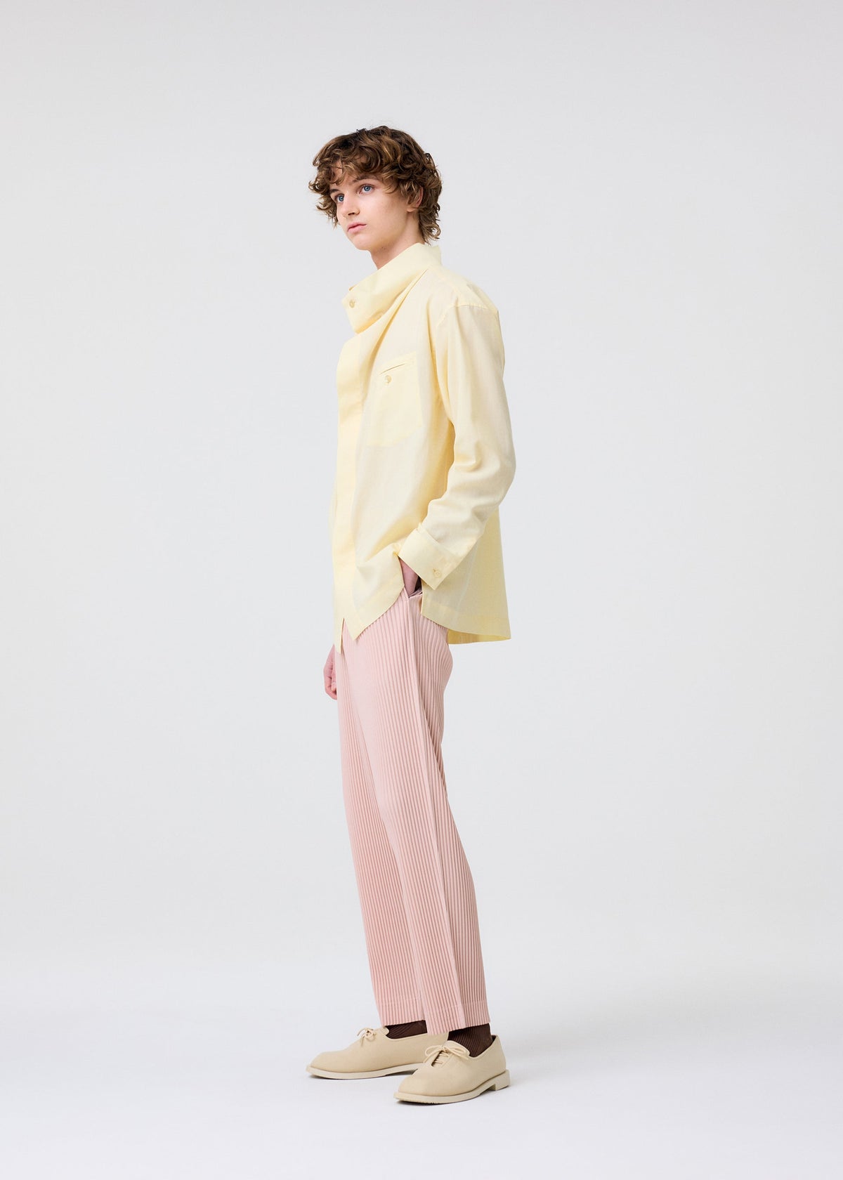 A model wears the HOMME PLISSÉ ISSEY MIYAKE COLOR PLEATS 2 trousers.