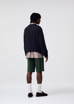 A model wears the HOMME PLISSÉ ISSEY MIYAKE COLOR PLEATS 2 shorts.