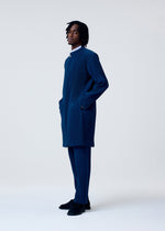 A model wears the HOMME PLISSÉ ISSEY MIYAKE TAILORED PLEATS 1 trousers.