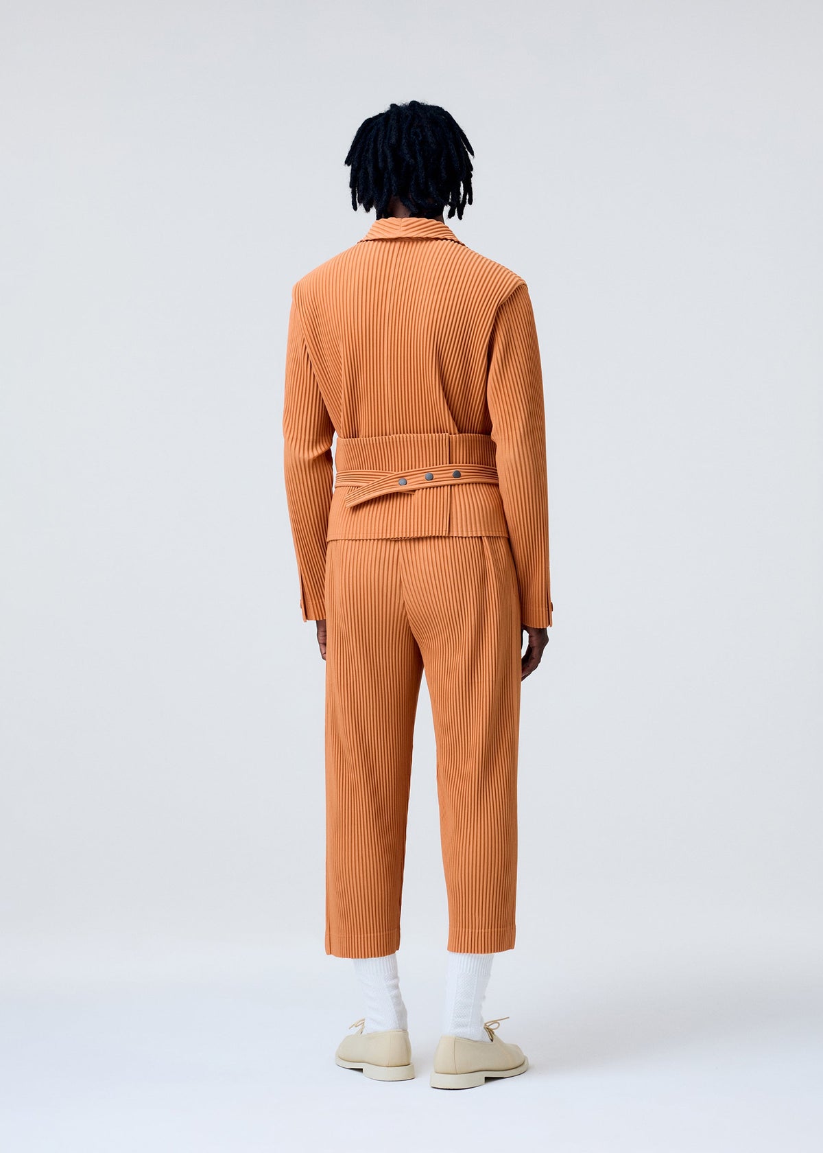 A model wears the HOMME PLISSÉ ISSEY MIYAKE TAILORED PLEATS 2 trousers.