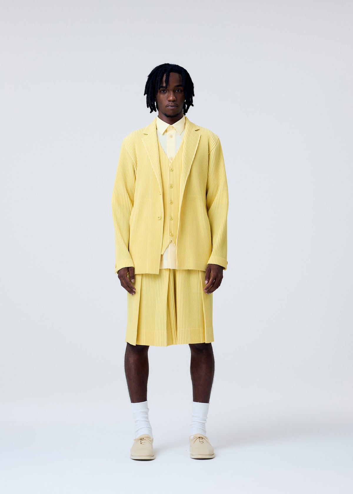 A model wears the HOMME PLISSÉ ISSEY MIYAKE TAILORED PLEATS 2 trousers.