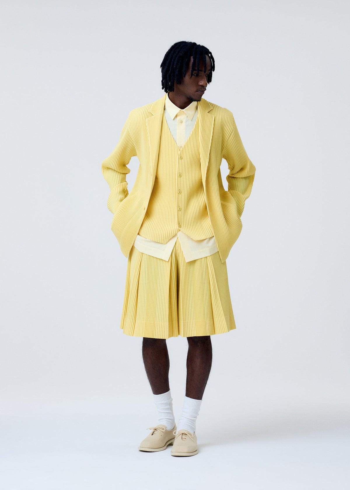 A model wears the HOMME PLISSÉ ISSEY MIYAKE TAILORED PLEATS 2 trousers.