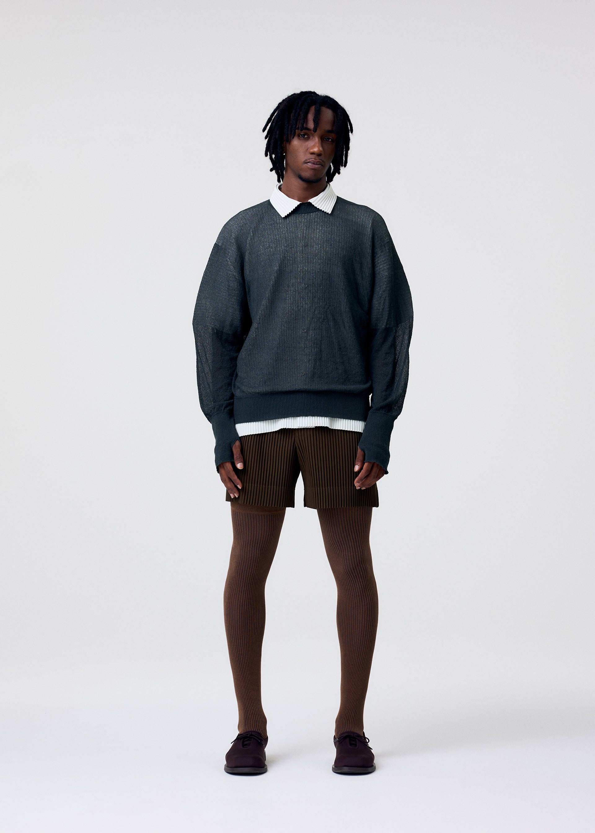 A model wears the HOMME PLISSÉ ISSEY MIYAKE TAILORED PLEATS 3 tailored-pleats-3-trousers-genova-metal-ochre-1.