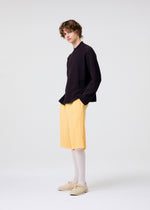 A model wears the HOMME PLISSÉ ISSEY MIYAKE WEAR OR WRAP trousers.