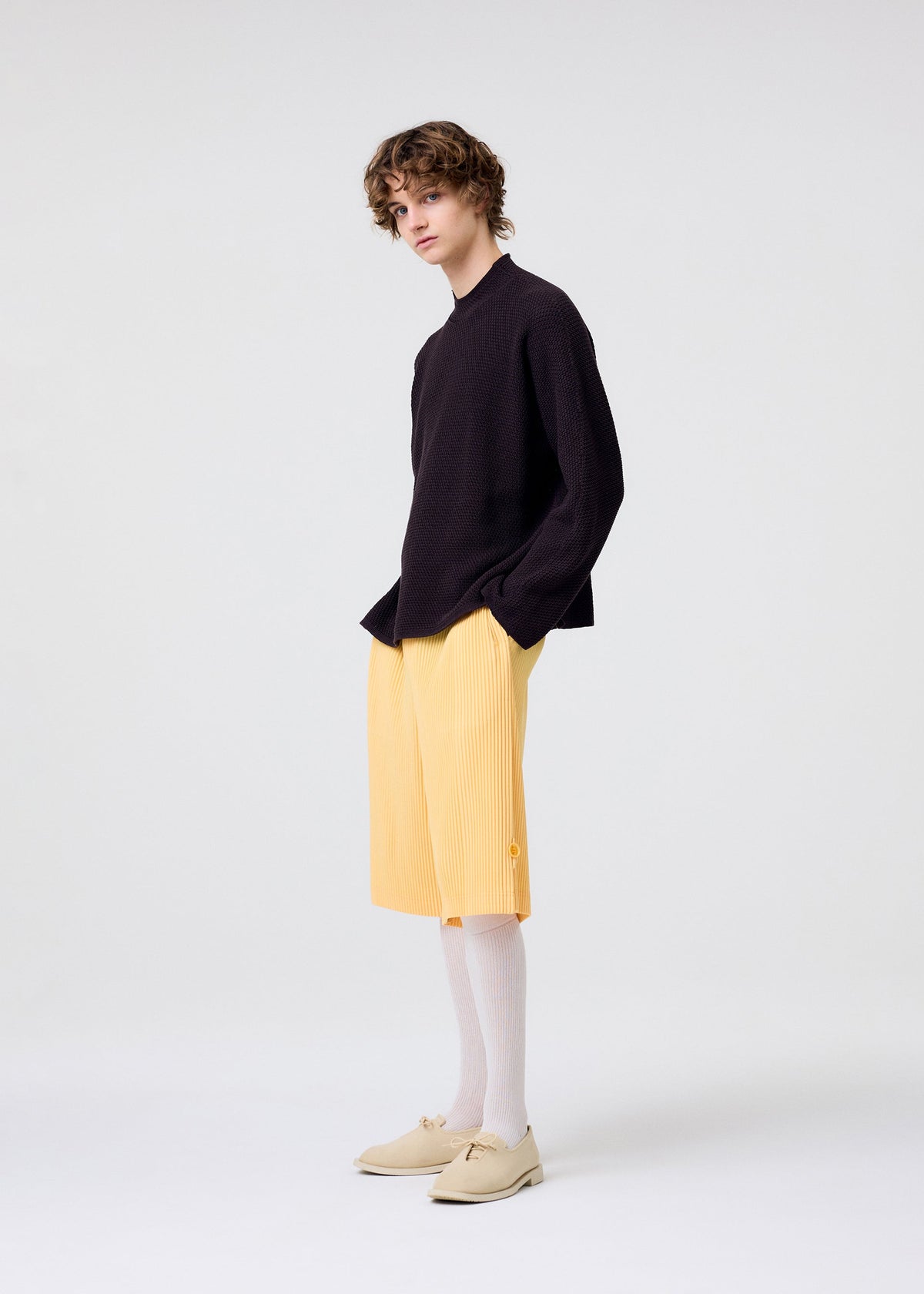 A model wears the HOMME PLISSÉ ISSEY MIYAKE WEAR OR WRAP trousers.