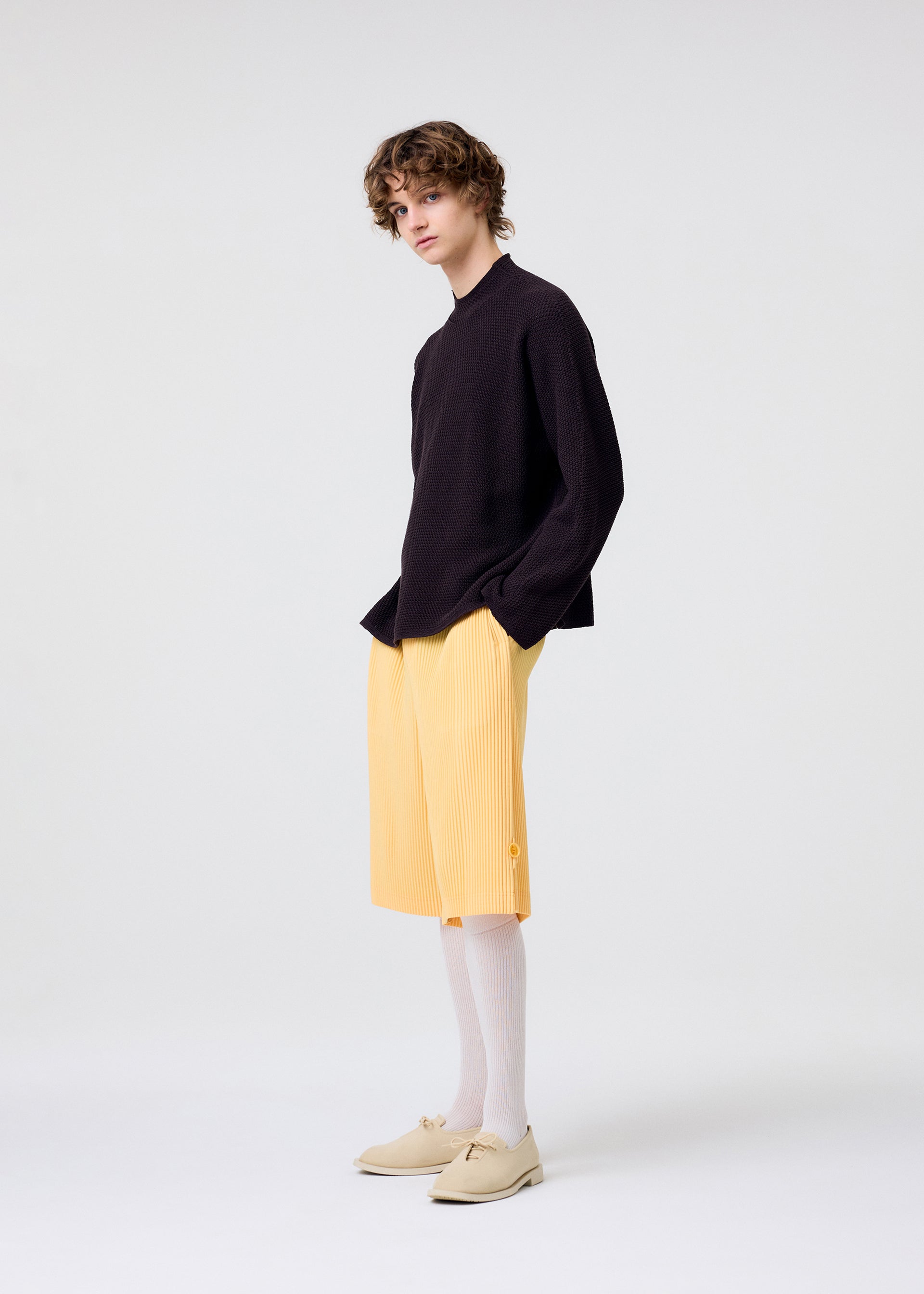 A model wears the HOMME PLISSÉ ISSEY MIYAKE WEAR OR WRAP trousers.