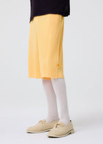 A model wears the HOMME PLISSÉ ISSEY MIYAKE WEAR OR WRAP trousers.