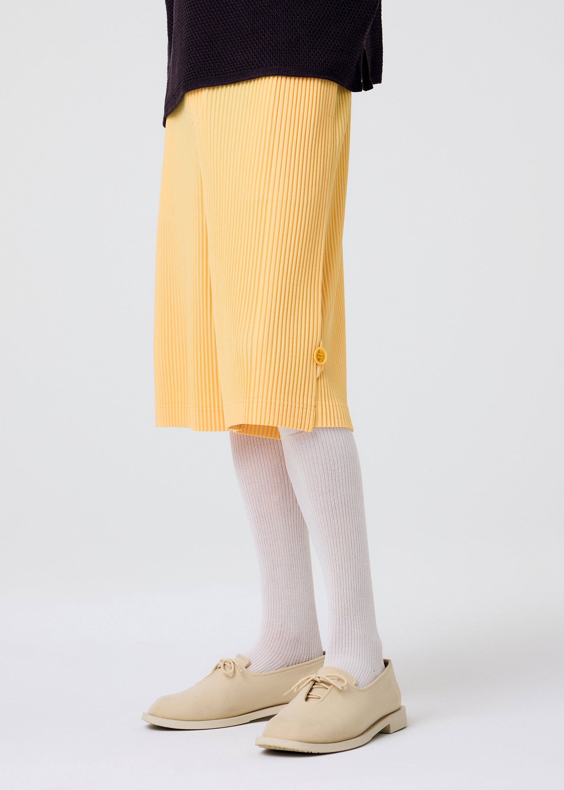 A model wears the HOMME PLISSÉ ISSEY MIYAKE WEAR OR WRAP trousers.