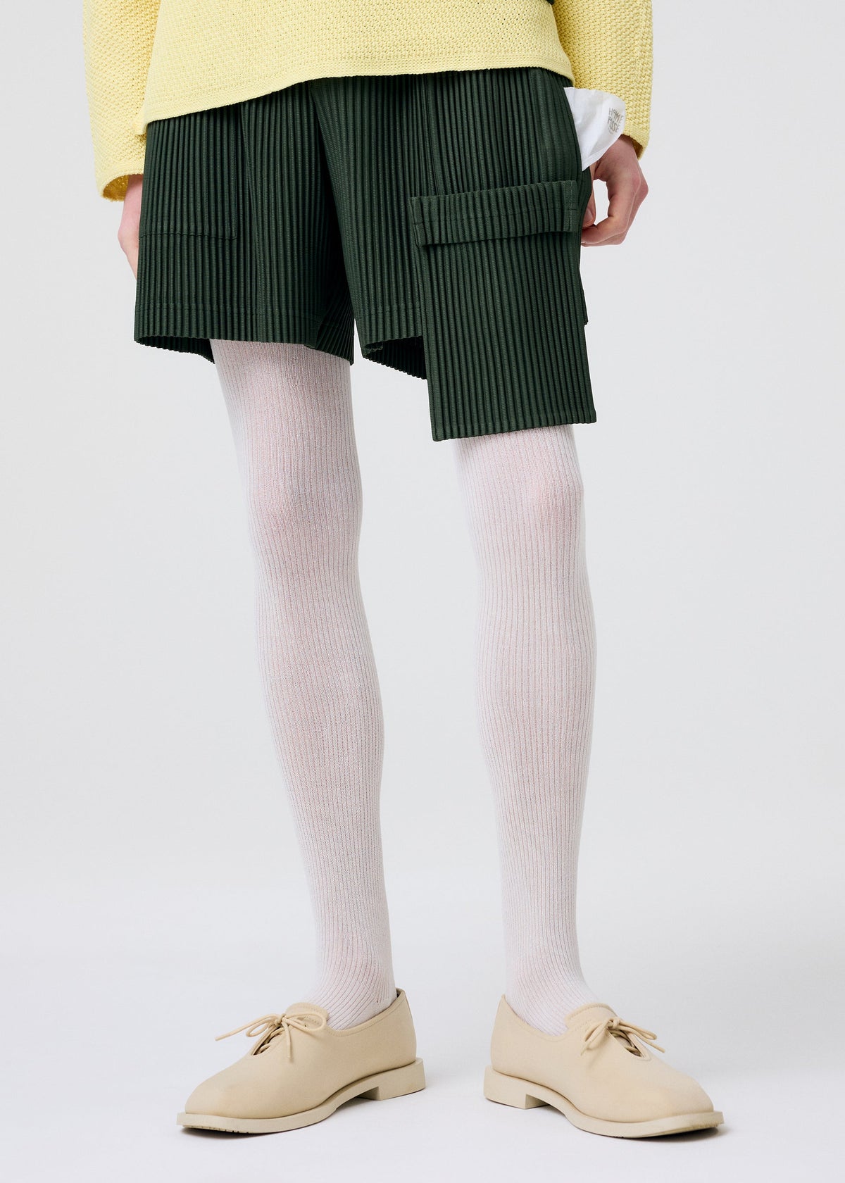 A model wears the HOMME PLISSÉ ISSEY MIYAKE PAINTER'S GEAR trousers.