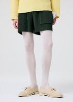 A model wears the HOMME PLISSÉ ISSEY MIYAKE PAINTER'S GEAR trousers.