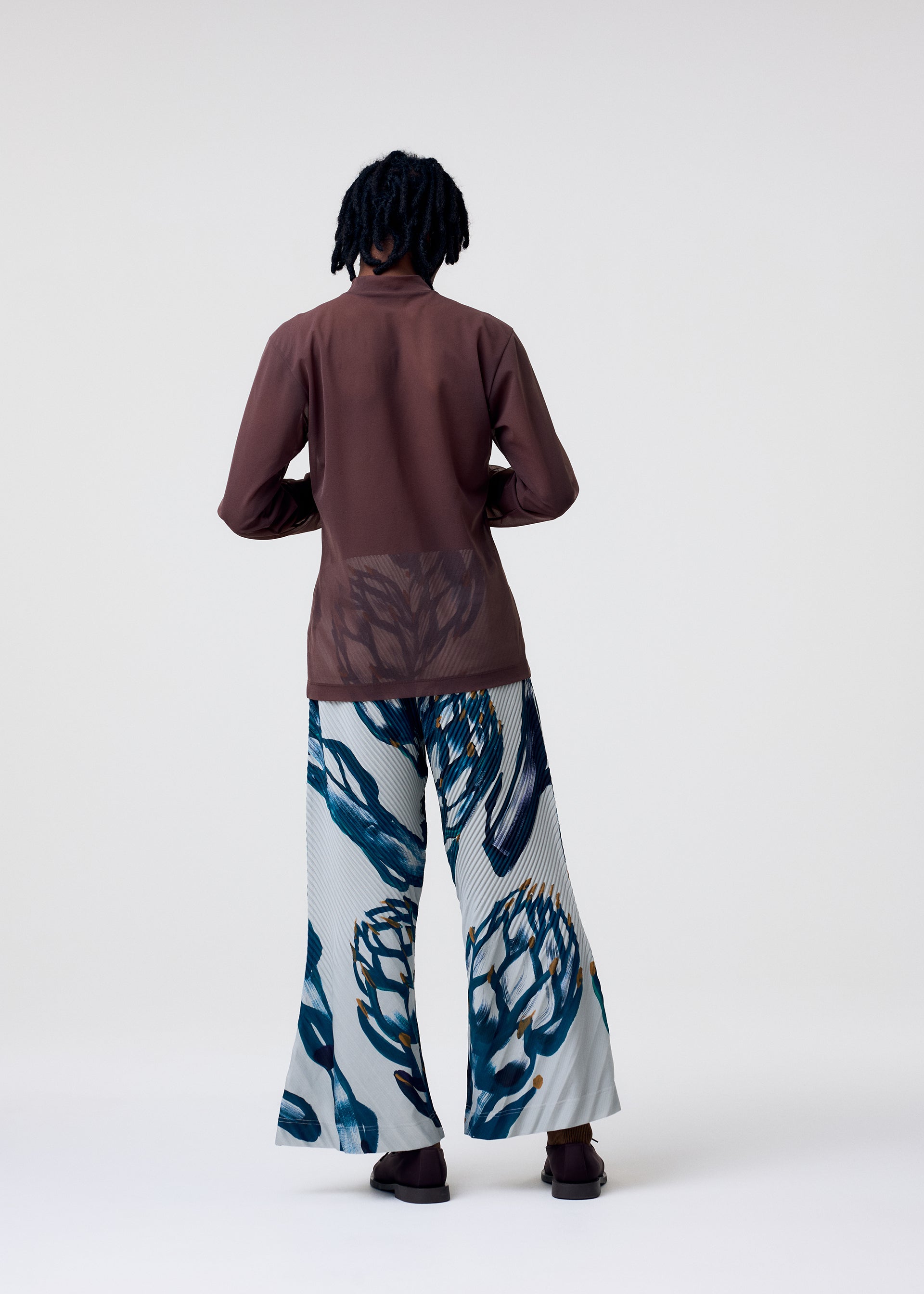 A model wears the HOMME PLISSÉ ISSEY MIYAKE FRUITS & VEGETABLES trousers.