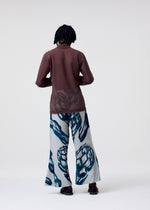 A model wears the HOMME PLISSÉ ISSEY MIYAKE FRUITS & VEGETABLES trousers.