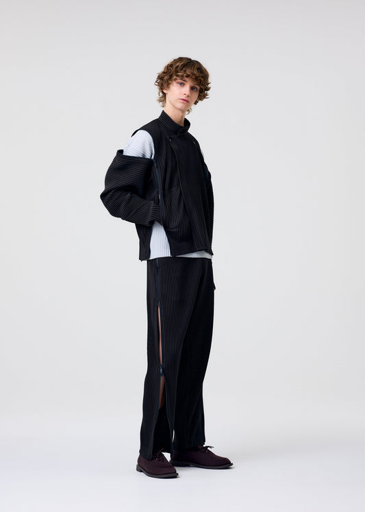 A model wears the HOMME PLISSÉ ISSEY MIYAKE MULTI-FASTENED multi-fastened-trousers-pizza-scorch-brown.