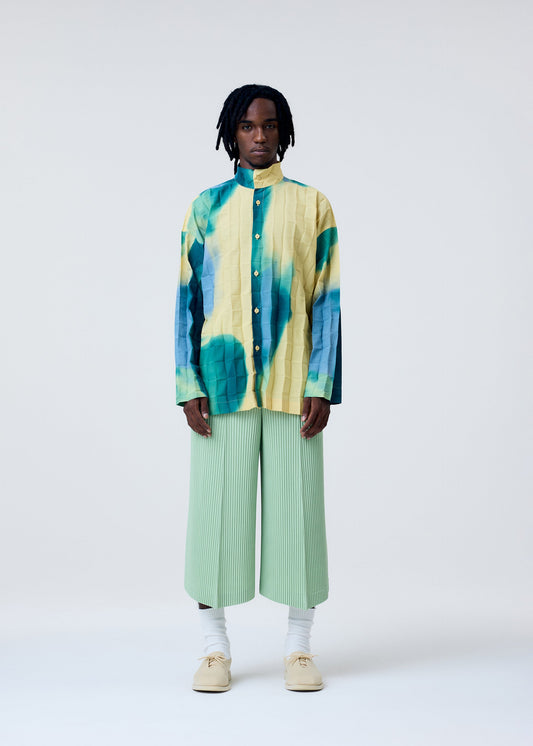 A model wears the HOMME PLISSÉ ISSEY MIYAKE PLEATS BOTTOMS 2 trousers.