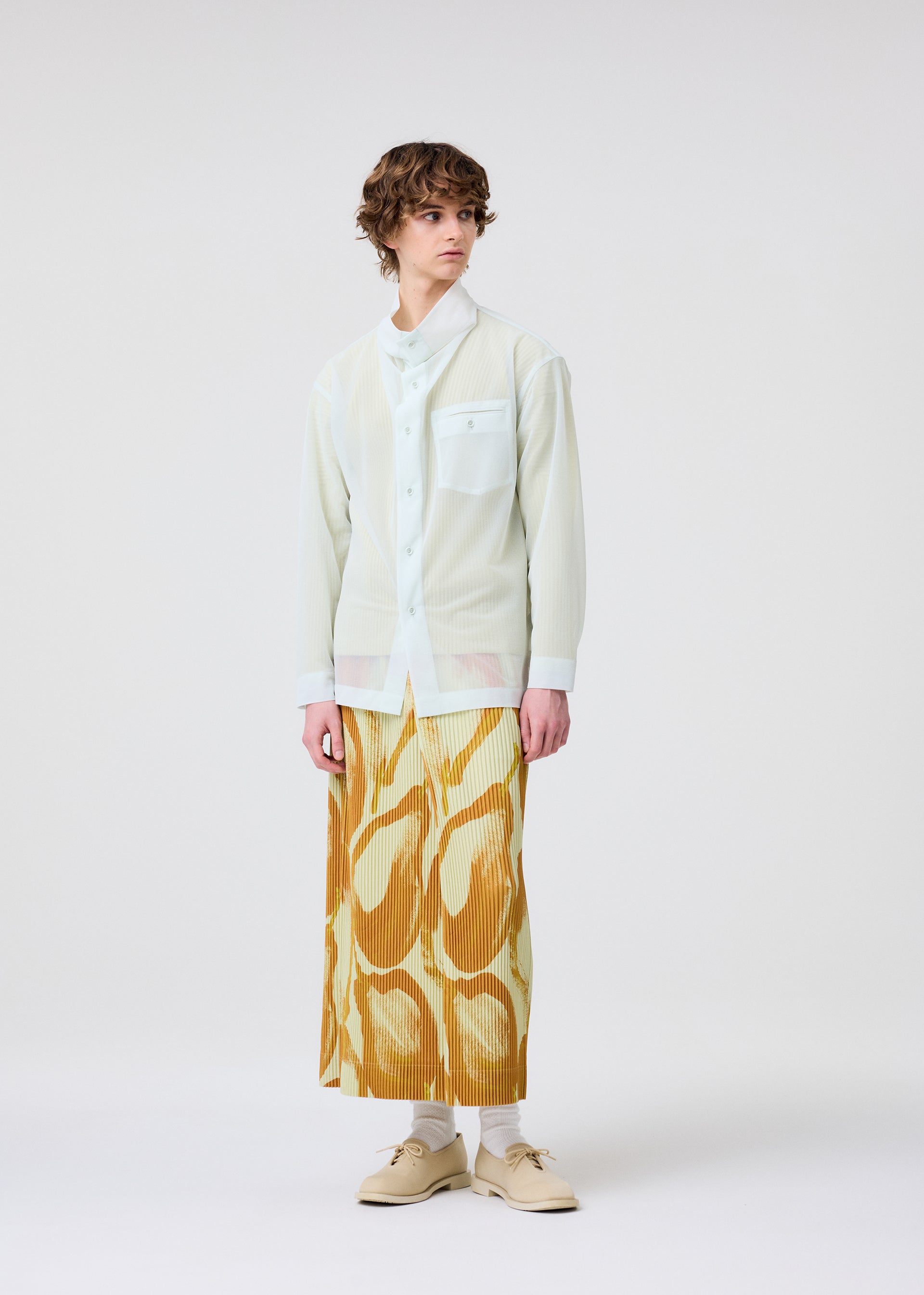 A model wears the HOMME PLISSÉ ISSEY MIYAKE FRUITS & VEGETABLES skirt.