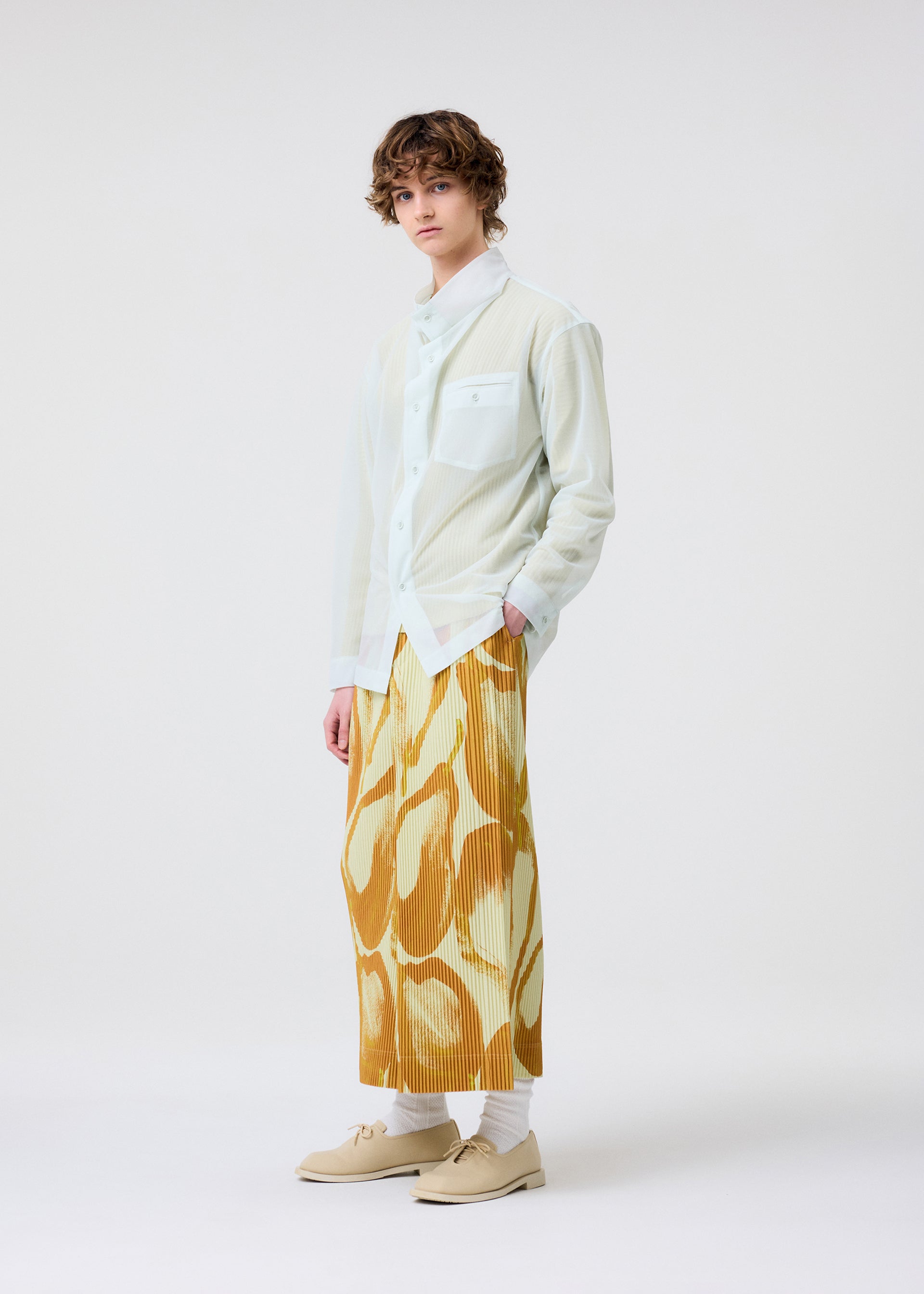 A model wears the HOMME PLISSÉ ISSEY MIYAKE FRUITS & VEGETABLES skirt.