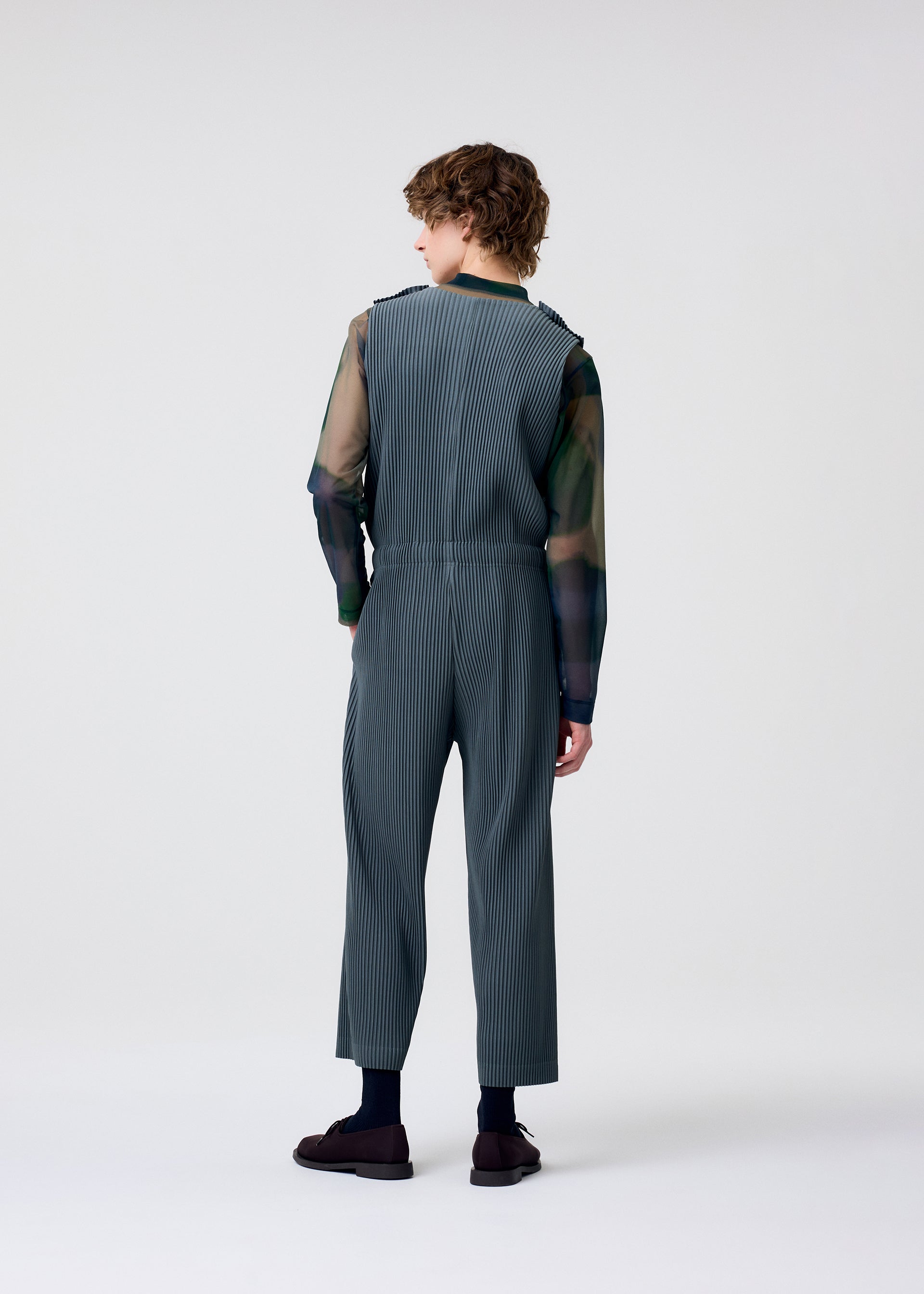 A model wears the HOMME PLISSÉ ISSEY MIYAKE PLEATS BOTTOMS 2 jumpsuit.