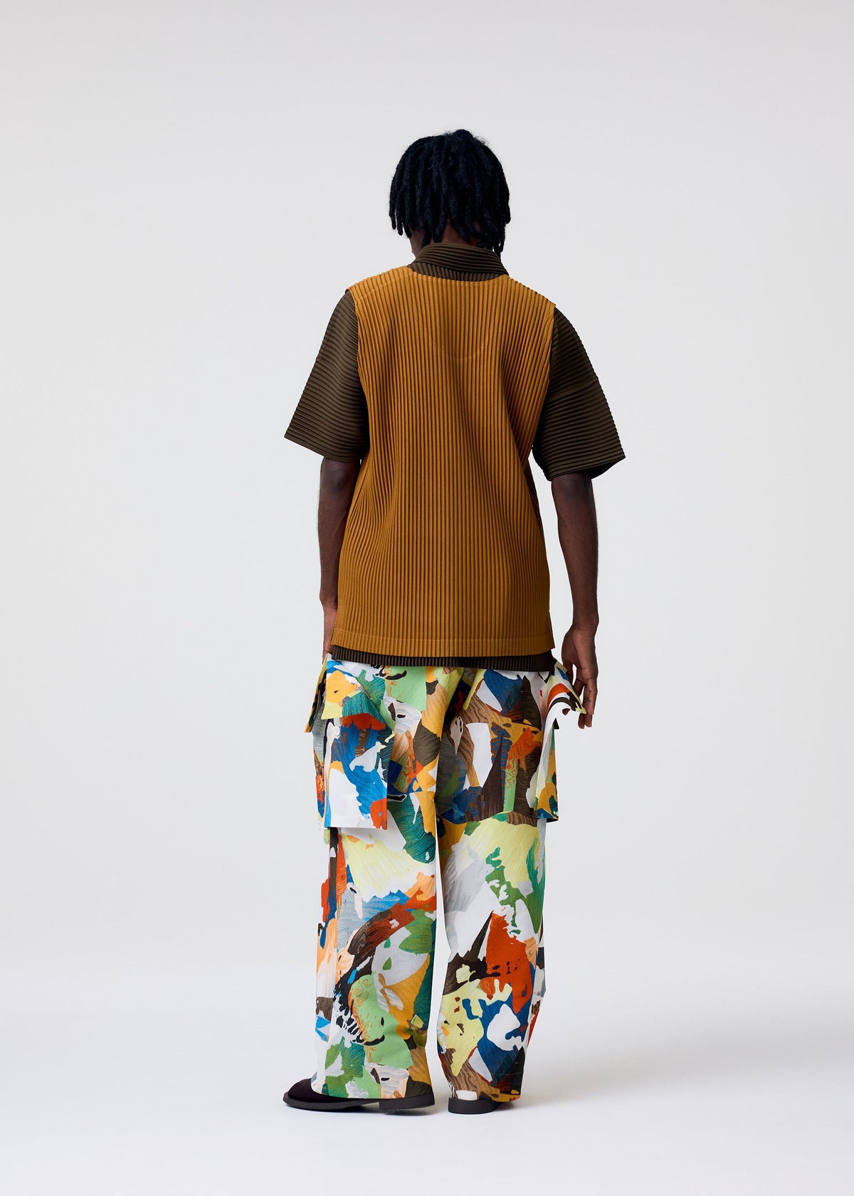 A model wears the HOMME PLISSÉ ISSEY MIYAKE MONTHLY COLORS : JUNE monthly-colors-june-top-genova-metal-ochre.