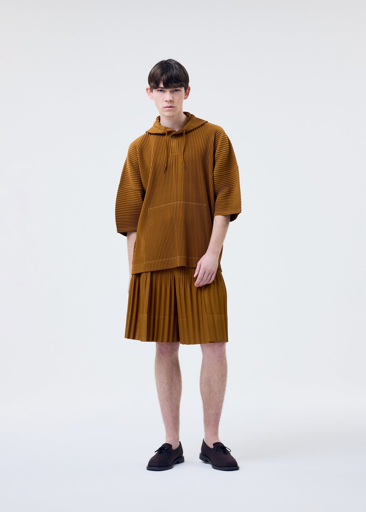 A model wears the HOMME PLISSÉ ISSEY MIYAKE MONTHLY COLORS : JUNE monthly-colors-june-top-genova-metal-ochre-1.