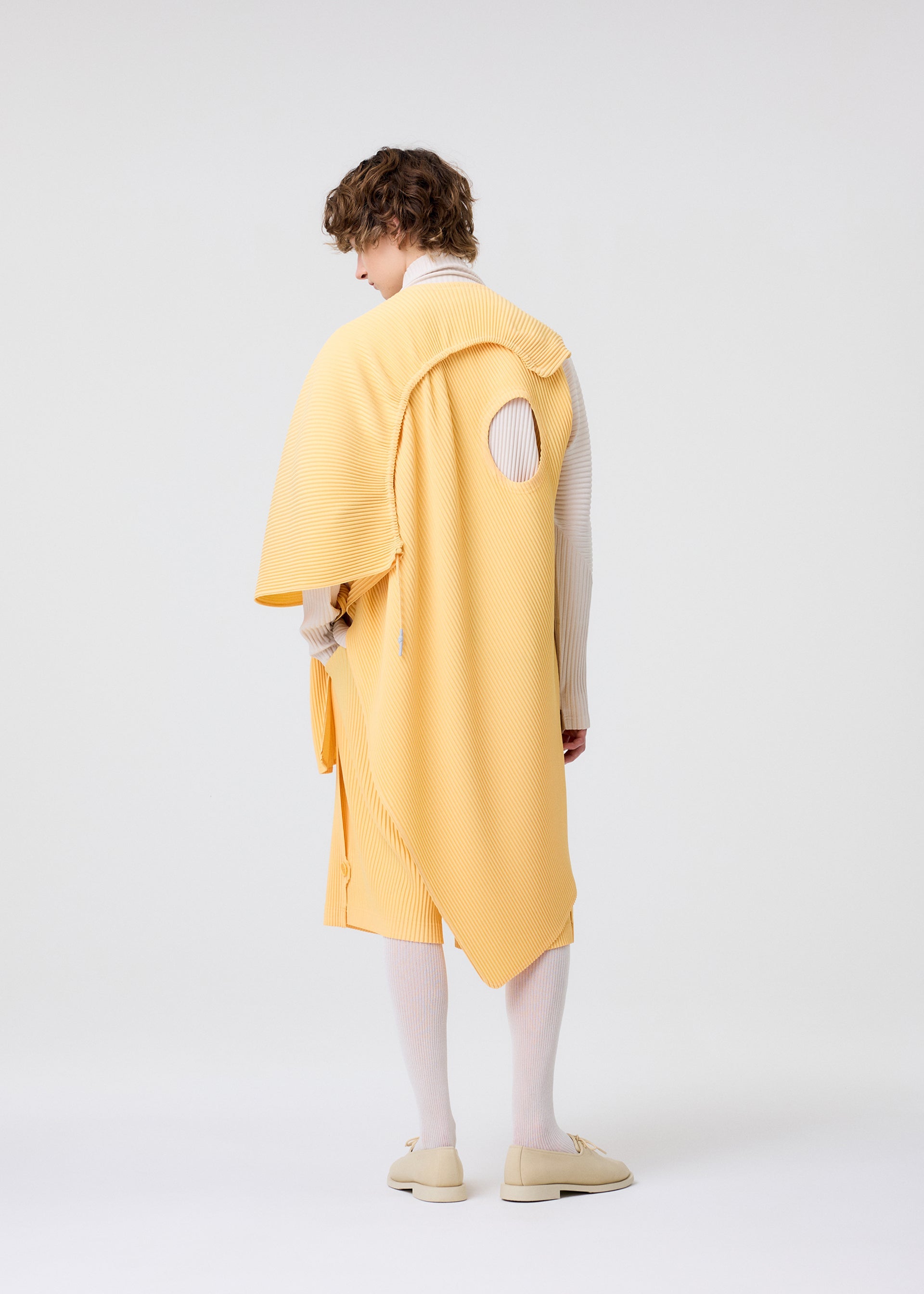 A model wears the HOMME PLISSÉ ISSEY MIYAKE WEAR OR WRAP top.