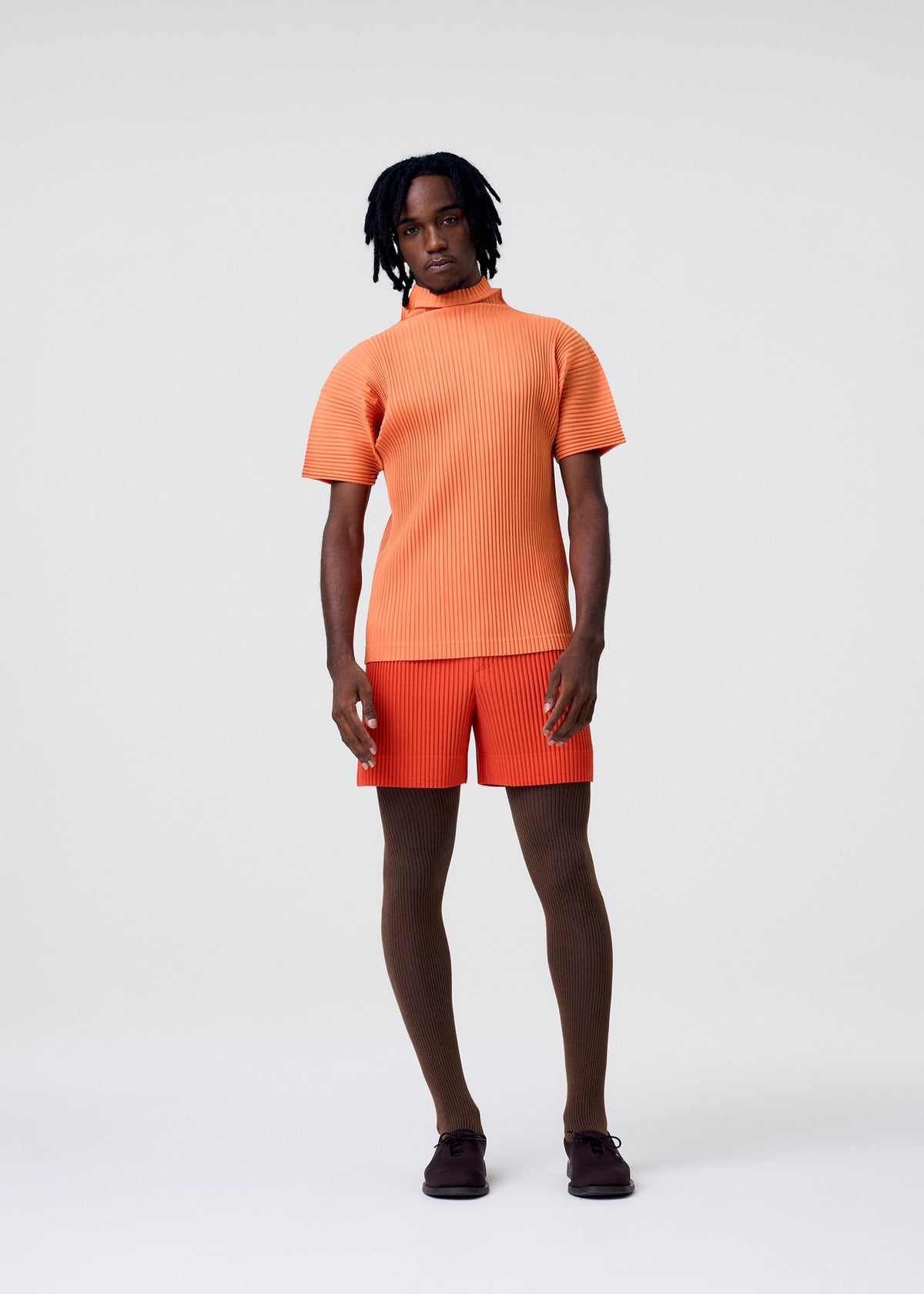 A model wears the HOMME PLISSÉ ISSEY MIYAKE AGAVE MESH agave-mesh-top-light-grey.