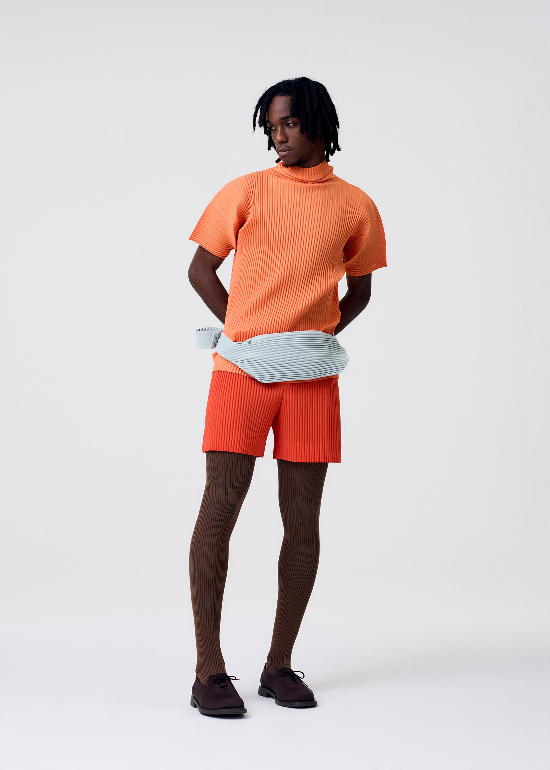 A model wears the HOMME PLISSÉ ISSEY MIYAKE AGAVE MESH agave-mesh-top-light-grey.