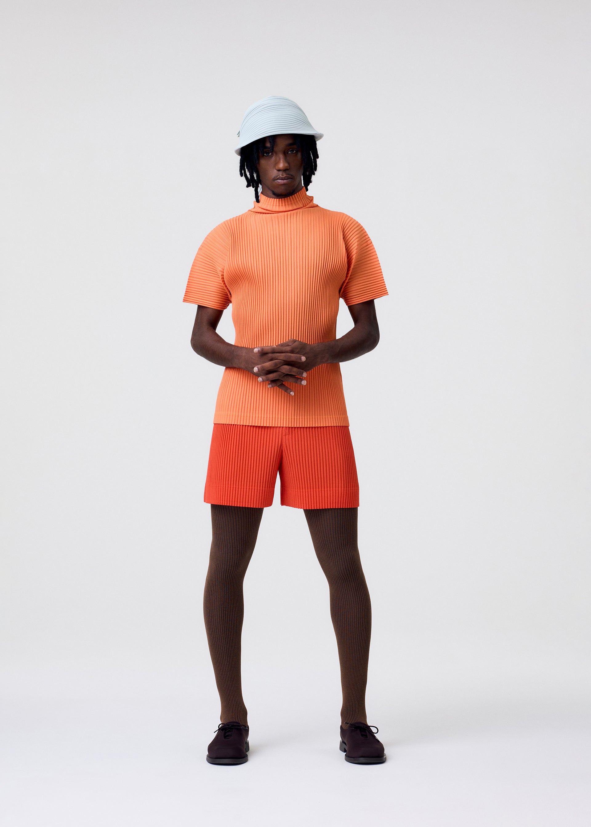 A model wears the HOMME PLISSÉ ISSEY MIYAKE AGAVE MESH agave-mesh-top-light-grey.