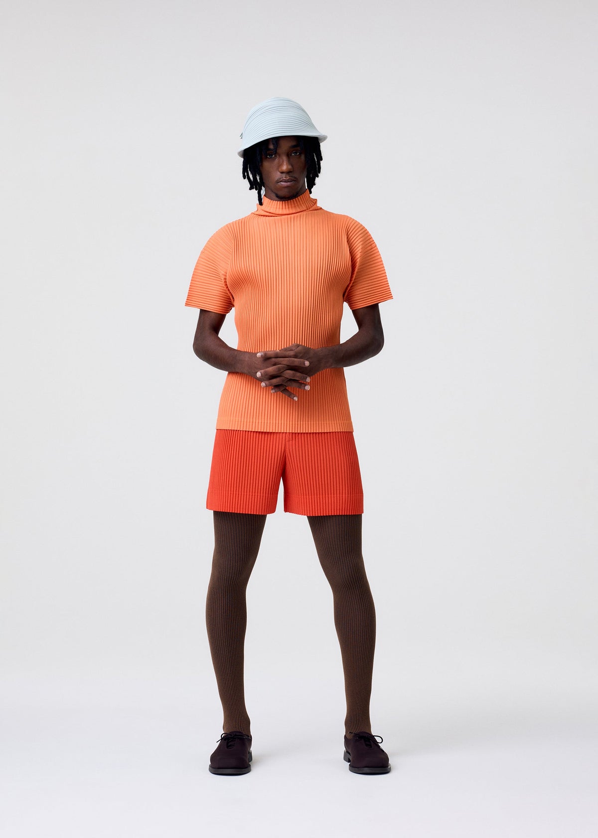 A model wears the HOMME PLISSÉ ISSEY MIYAKE AGAVE MESH agave-mesh-top-green.