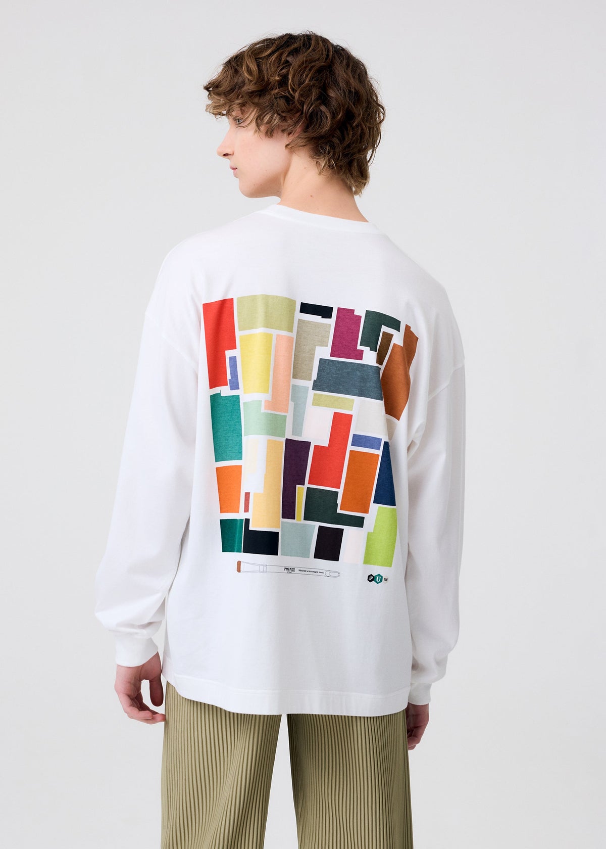 A model wears the HOMME PLISSÉ ISSEY MIYAKE COLOR CHIPS T SHIRT top.