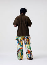 A model wears the HOMME PLISSÉ ISSEY MIYAKE MONTHLY COLORS : JUNE monthly-colors-june-shirt-venice-boat-brown.