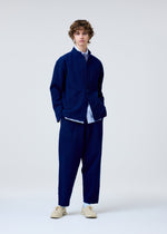 A model wears the HOMME PLISSÉ ISSEY MIYAKE INLAID KNIT jacket.