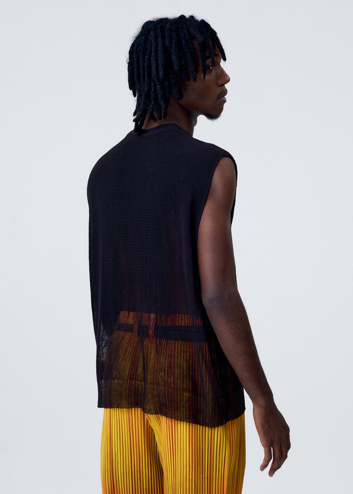 A model wears the HOMME PLISSÉ ISSEY MIYAKE BRUSH CLOSE UP KNIT vest.