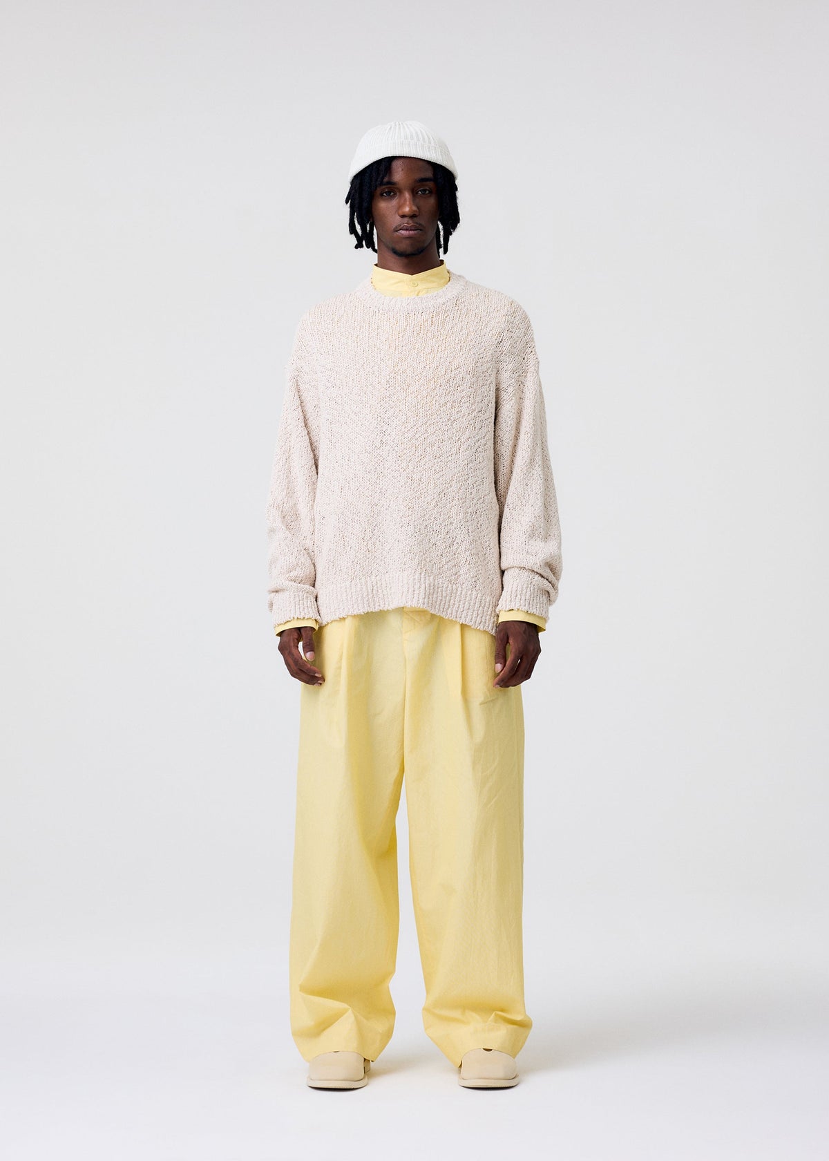A model wears the HOMME PLISSÉ ISSEY MIYAKE RISOTTO KNIT top.