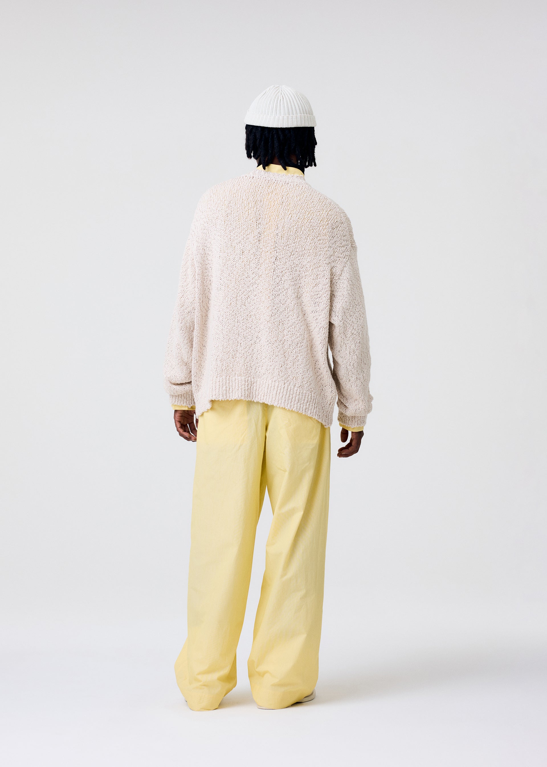 A model wears the HOMME PLISSÉ ISSEY MIYAKE RISOTTO KNIT top.