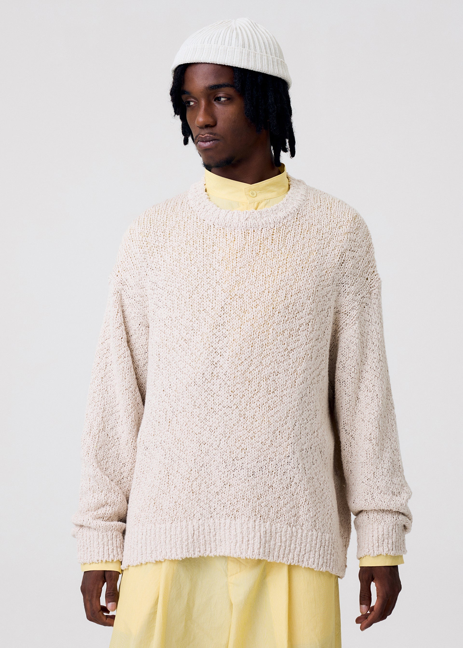 A model wears the HOMME PLISSÉ ISSEY MIYAKE RISOTTO KNIT top.