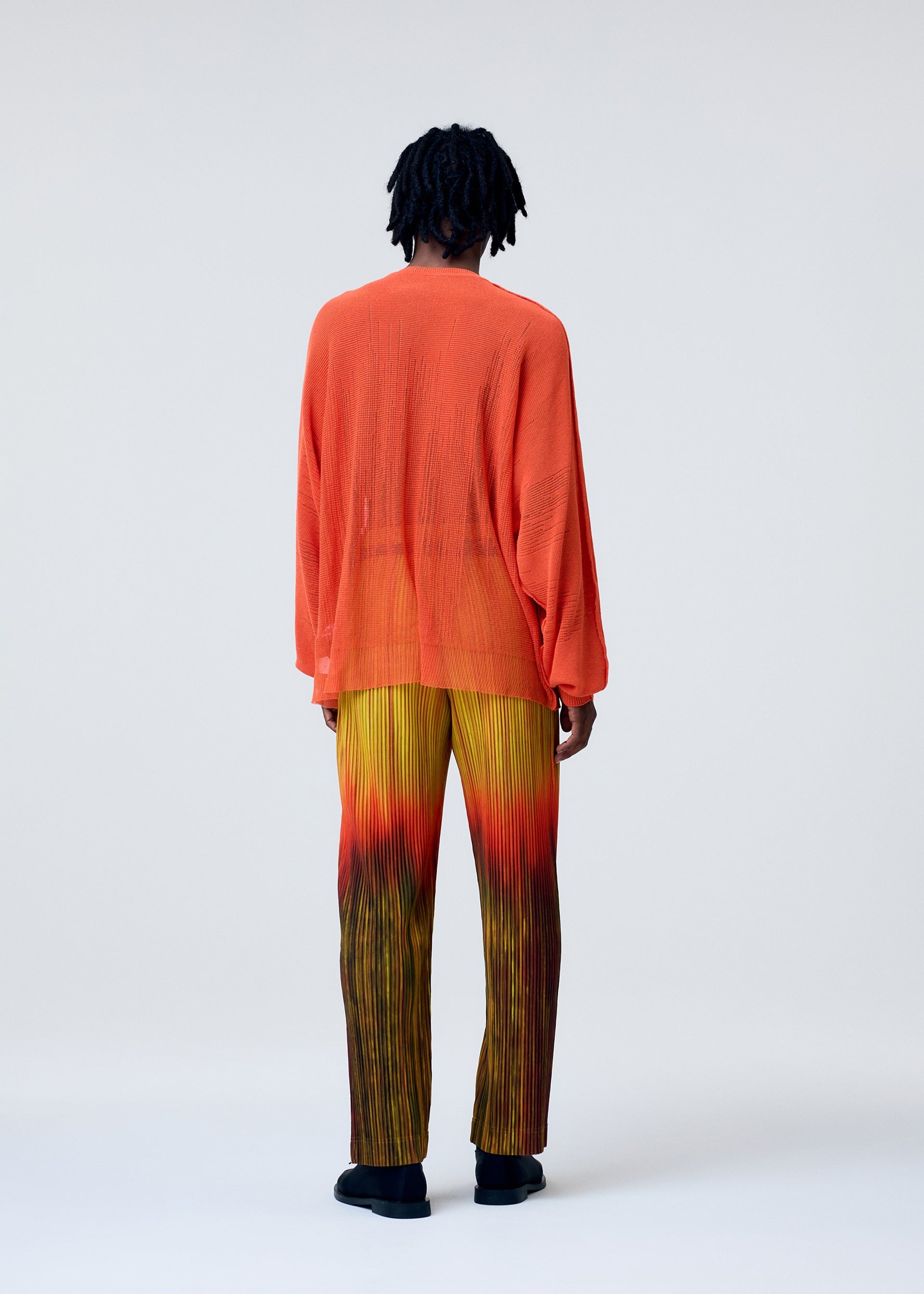 A model wears the HOMME PLISSÉ ISSEY MIYAKE BRUSH CLOSE UP KNIT top.